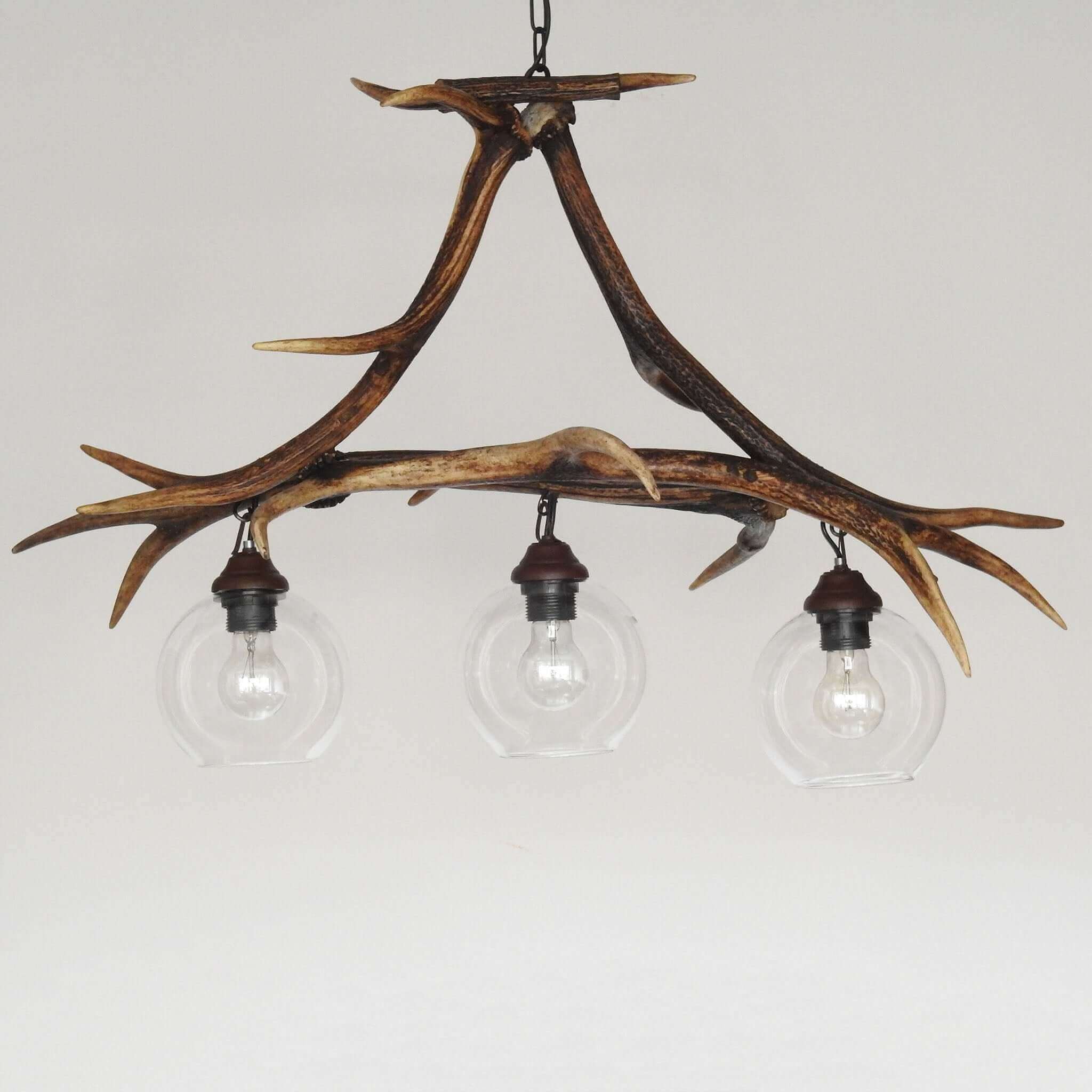 Stunning pendant lamp with three downward-facing bulbs, crafted from genuine red deer antlers.