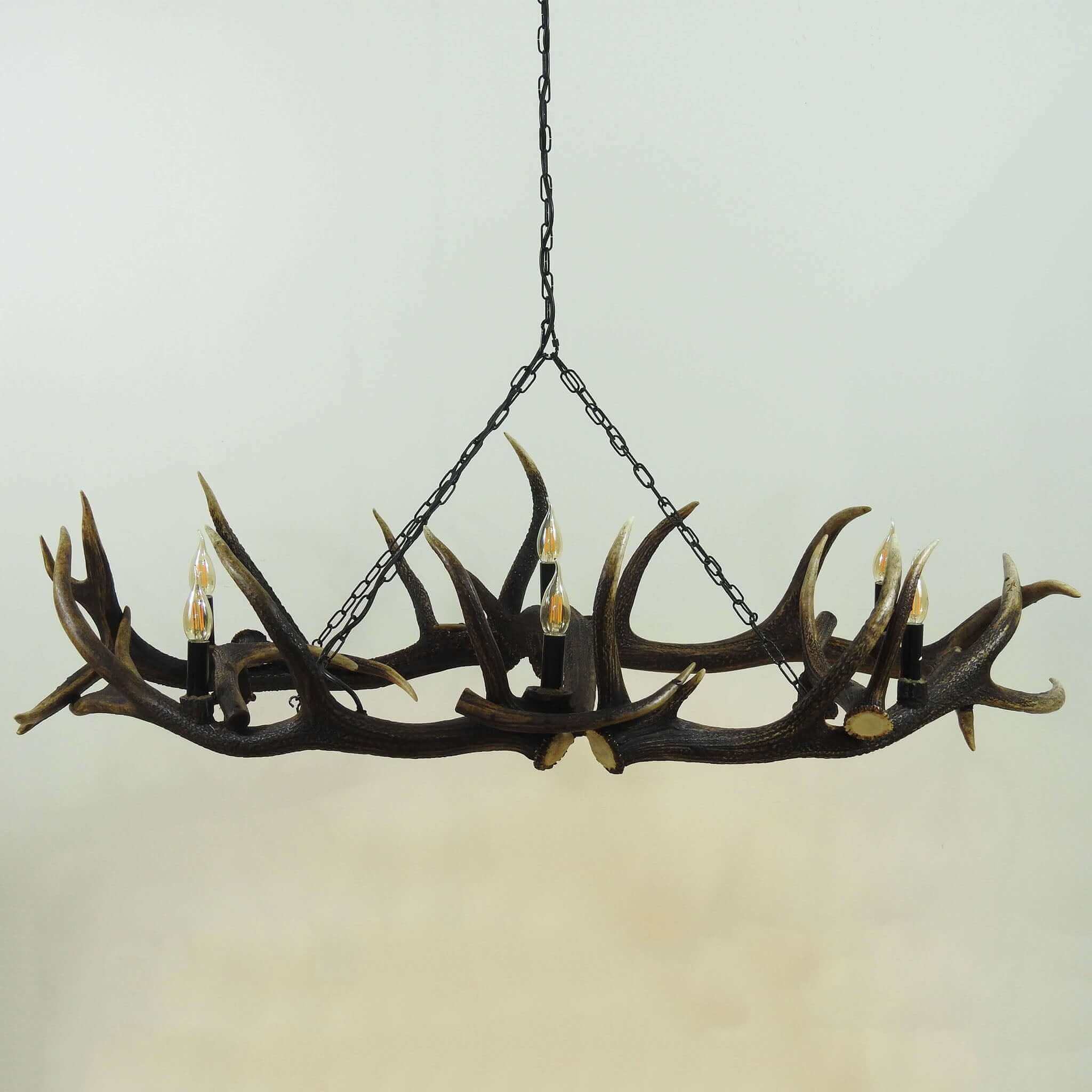 Deer antler chandelier hanging on chain.