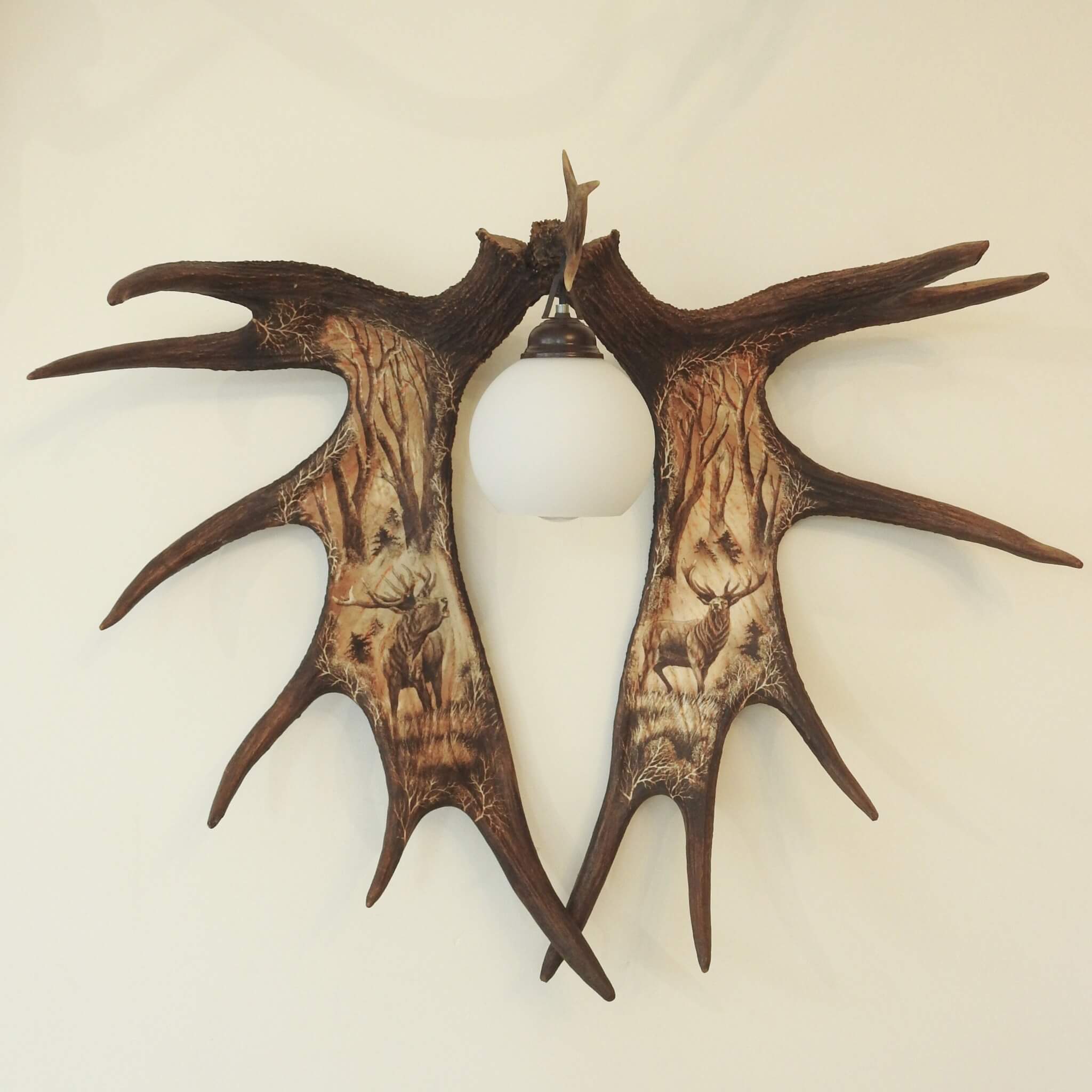 Antler wall sconce with deer carings.