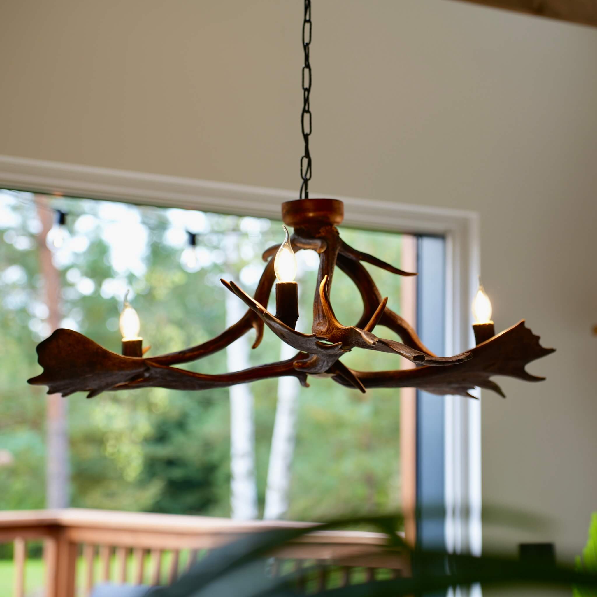 Elegant rustic chandelier with three candle-style lights and a natural antler design.
