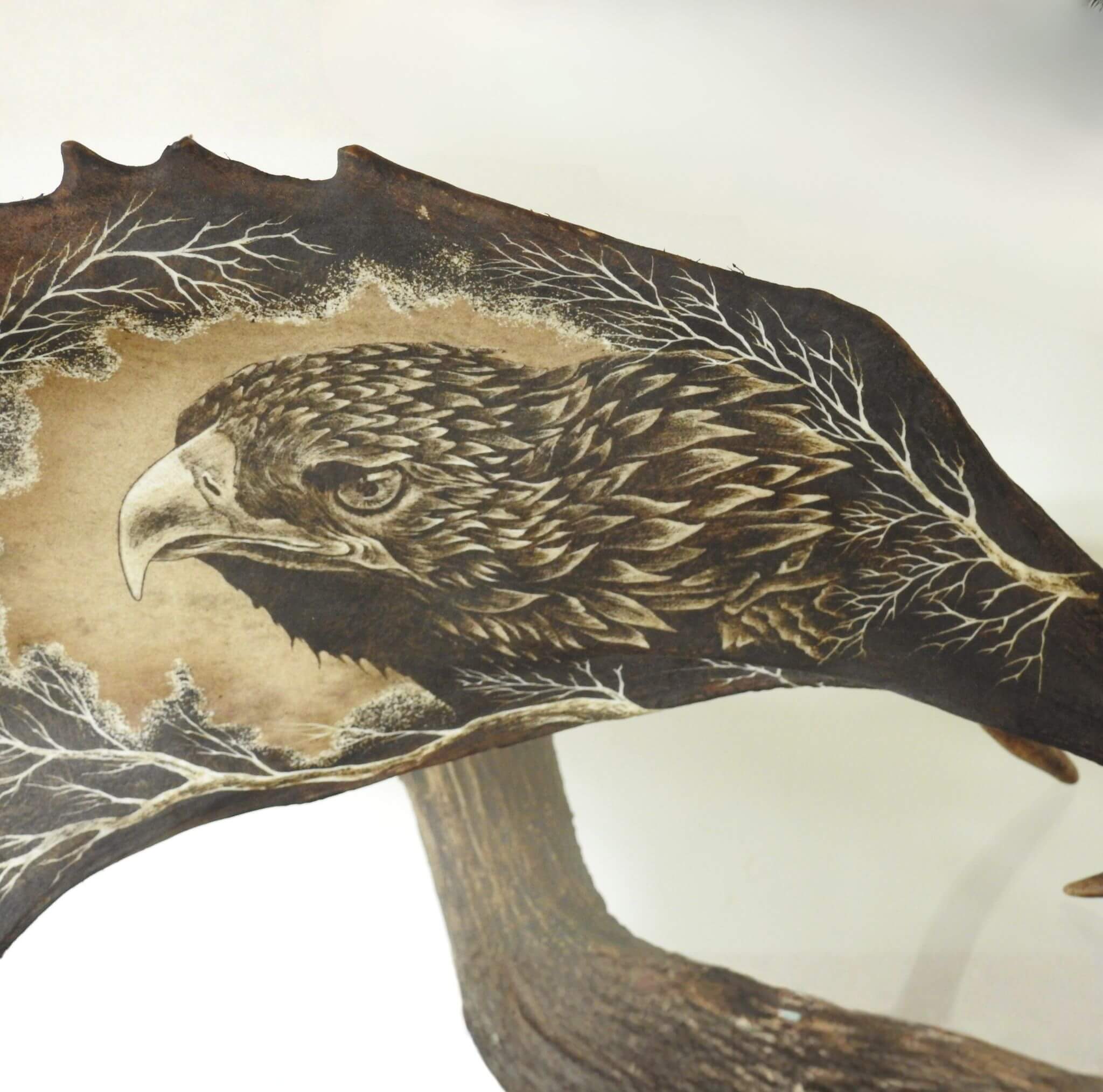 Antler carving of an eagle with a naturalistic design on a white background.