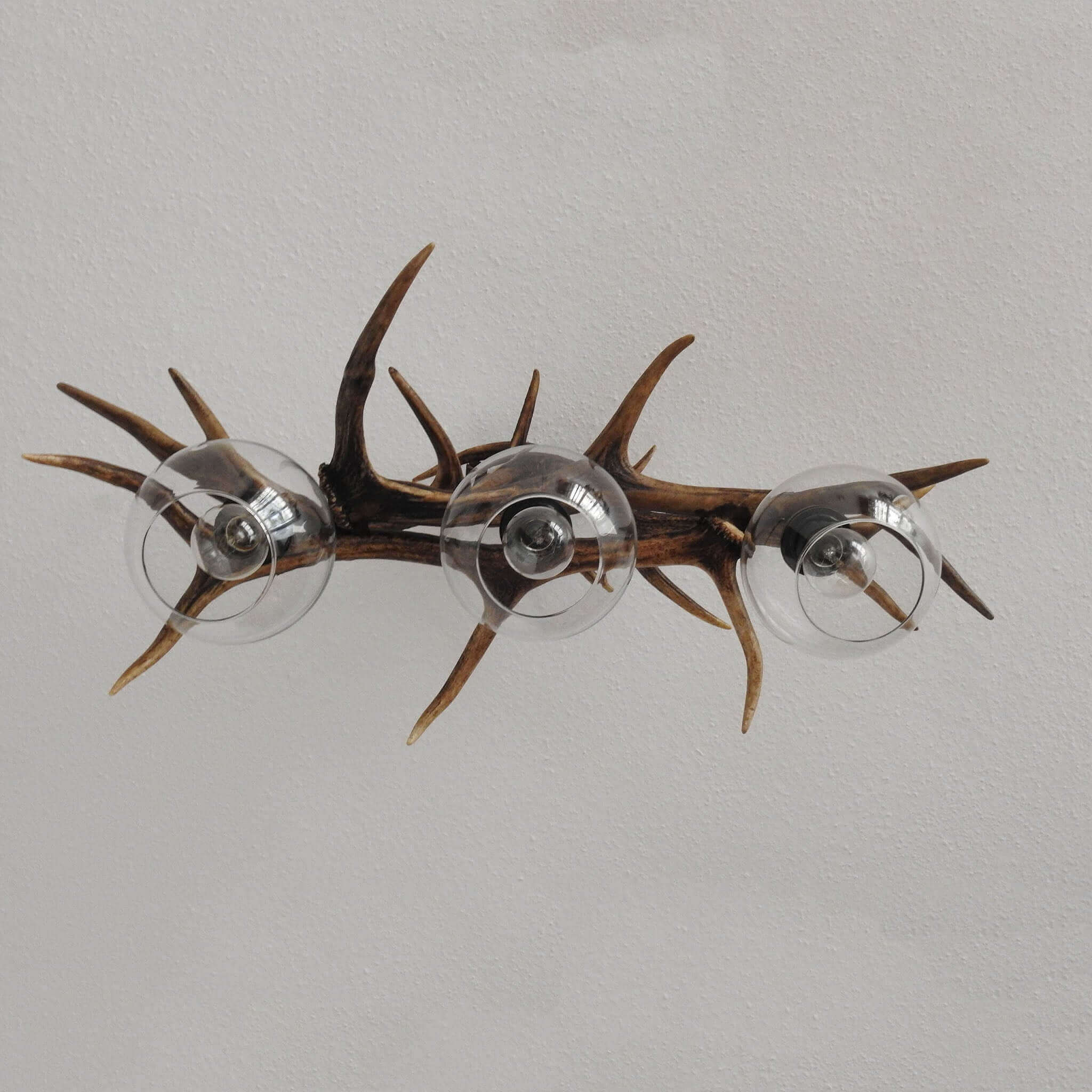 Nature-inspired pendant lamp with a sleek design, showcasing real red deer antlers and providing focused lighting.