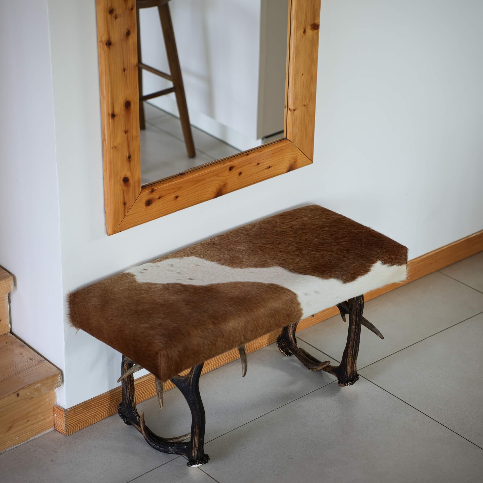 Real antler bench standing by staircase.