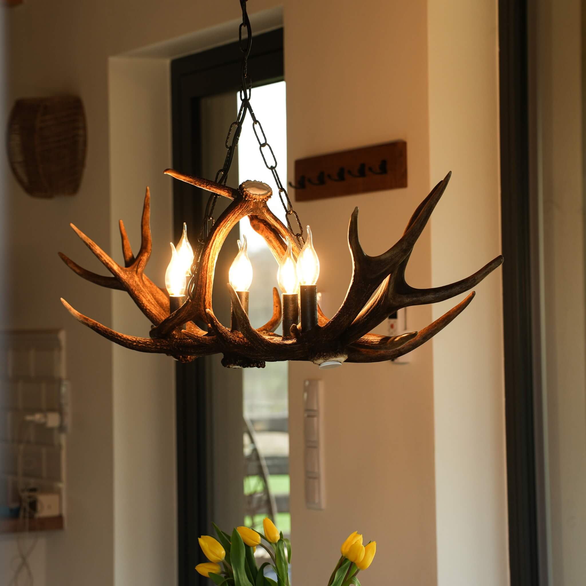 Linear rustic antler chandelier in farmhouse dining room.