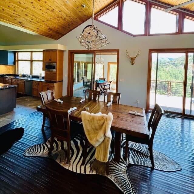 Colonial style home with open space dining room. Modern, white antler chandelier hangs over the table.