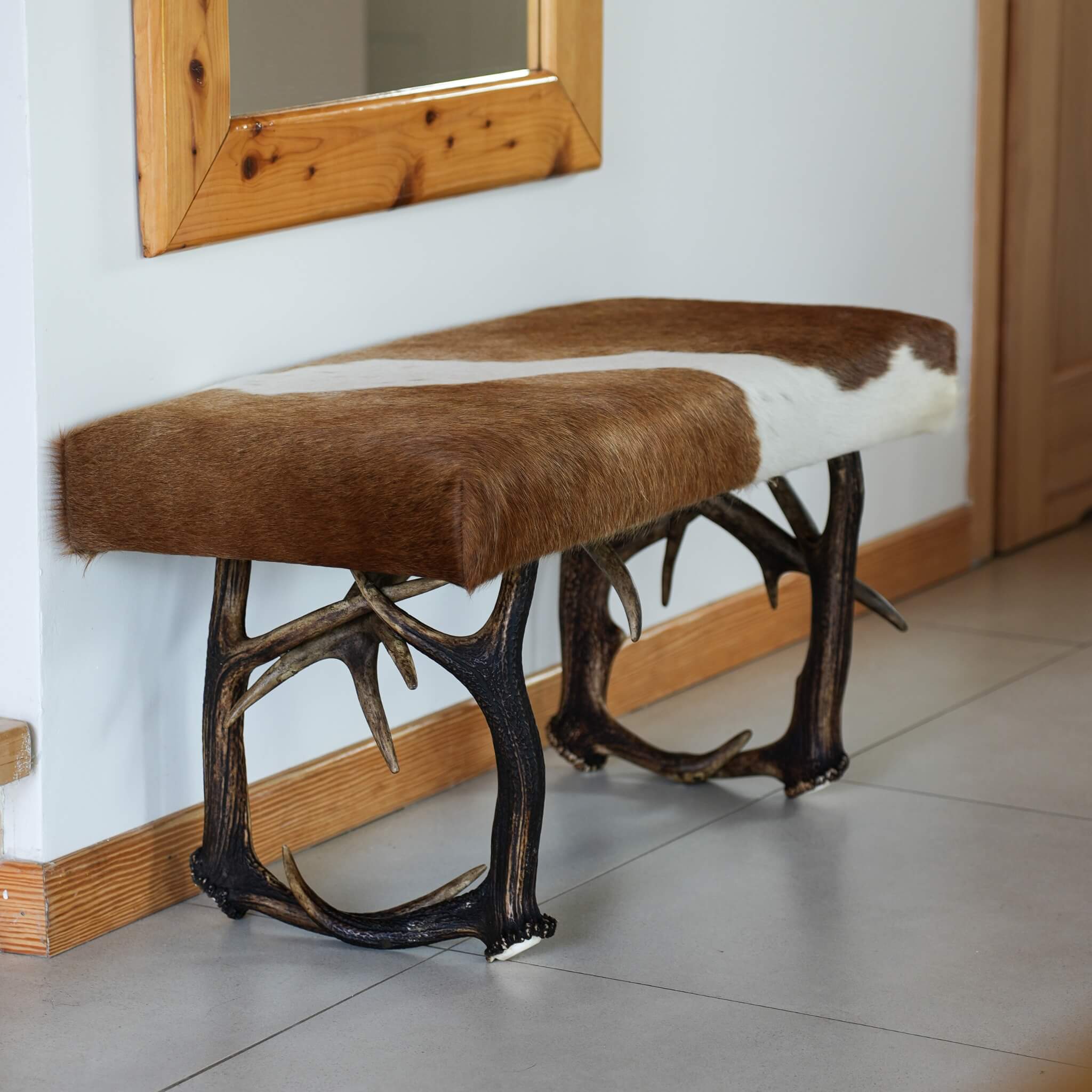 Cowhide bench with legs made of real deer antlers.